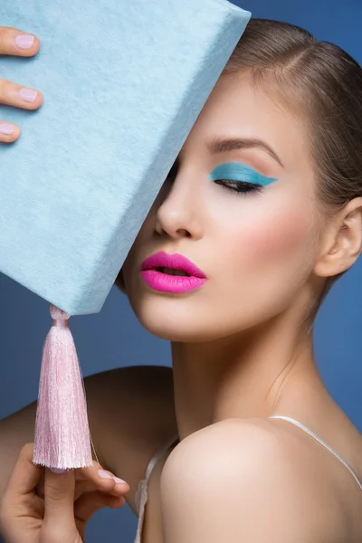 Meisje met heldere make-up holding boek — Stockfoto