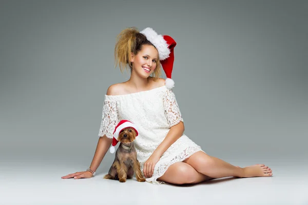 Belle fille avec chien yorkie en bonnet de Père Noël — Photo