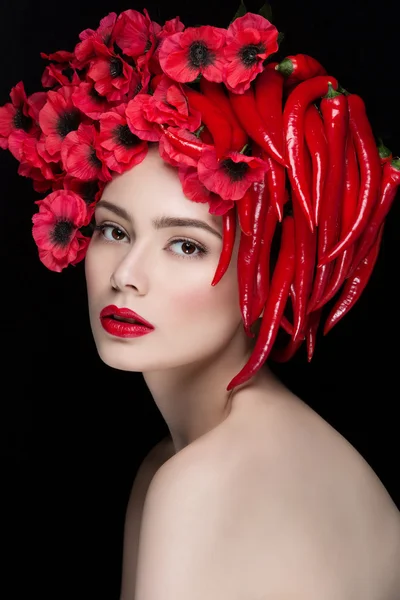 Girl with chilli peppers and flowers — Stock Photo, Image