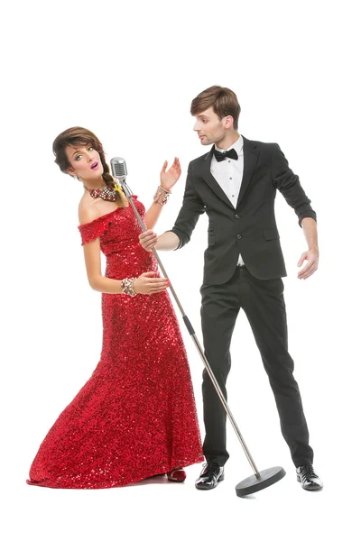 Женщина и мужчина исполняют песню в ретро-микрофоне — стоковое фото