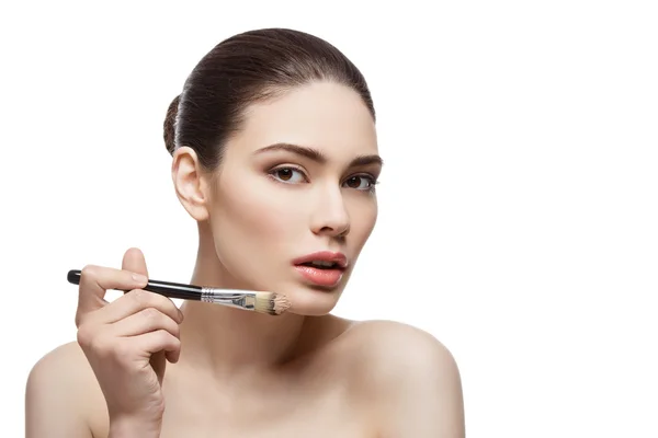 Beautiful girl applying foundation with brush — Stock Photo, Image