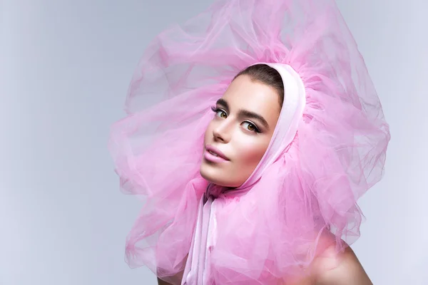 Vacker flicka i fluffiga rosa huvudbonader — Stockfoto
