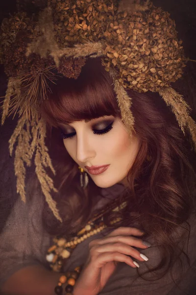 Красивая молодая женщина с сухими цветами на голове — стоковое фото
