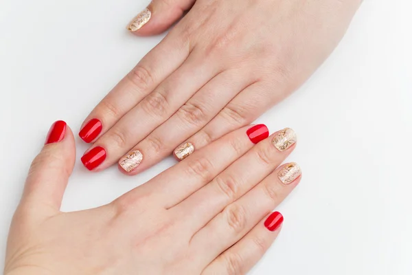 Mãos de mulher com manicure vermelho e dourado — Fotografia de Stock