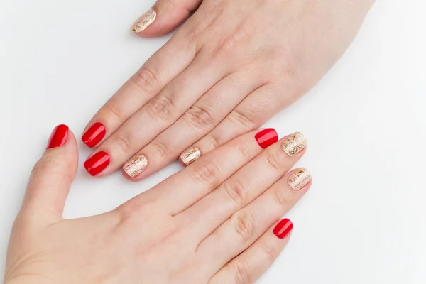 Manos de mujer con manicura roja y dorada — Foto de Stock