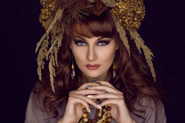 Красивая молодая женщина с сухими цветами на голове — стоковое фото