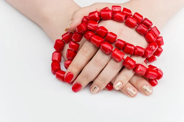 Mãos de mulher com manicure vermelho e dourado — Fotografia de Stock