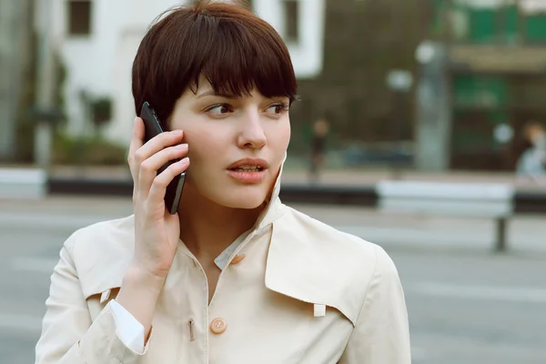 Belle fille avec un téléphone dans ses mains — Photo