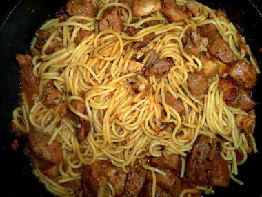 Kızartma tavasında makarna ile pişirilmiş et.