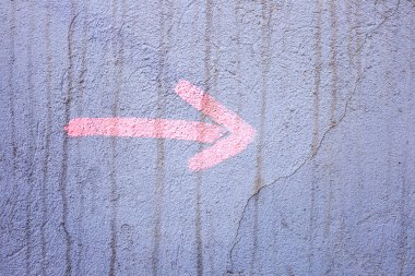 Sağdaki dışında bir grunge sıva duvar boyalı pembe bir ok gösterir