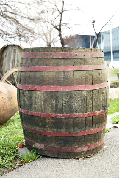 Old wooden barrel with iron rings is standing at the street.