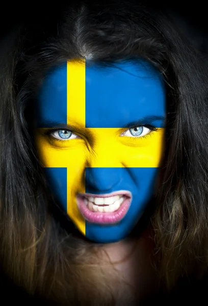 Portret kobiety z flaga Szwecji malowane na jej twarzy — Zdjęcie stockowe