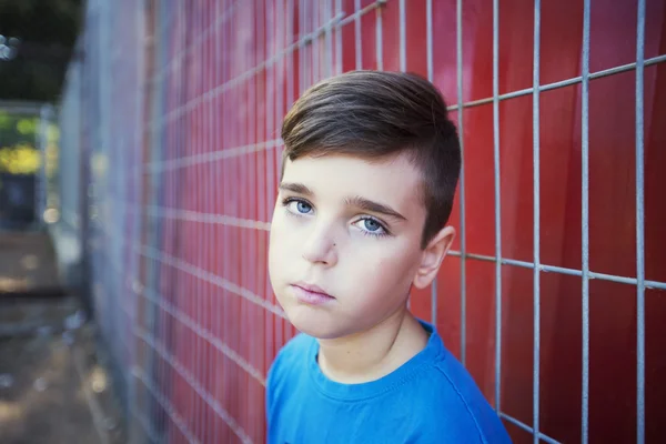Close-up van portret van een trieste tiener tegen een rode achtergrond — Stockfoto