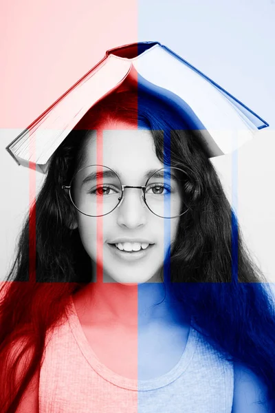 Entzückendes Mädchen mit Brille und Buch auf dem Kopf auf weißem Hintergrund — Stockfoto