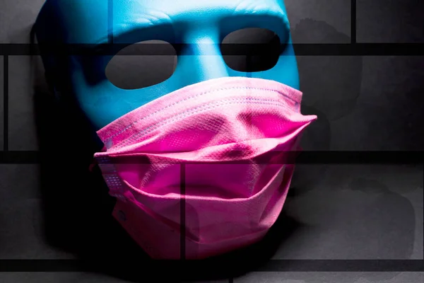 Medical pink mask put on a blue mask. black background — Stock Photo, Image
