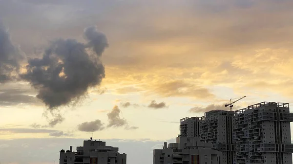 Bewolkte luchten geschilderd in prachtige kleuren over de stad — Stockfoto