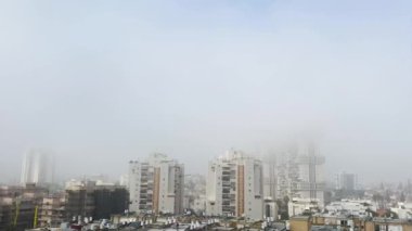  Pencereden bak. Şehrin üzerinde sis var.