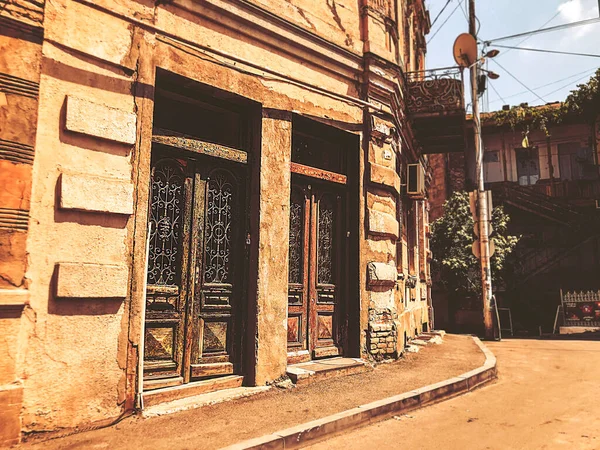 TBILISI, GEORGIA - July 10, 2018: Old Tbilisi architecture, yard, windows, flowers and green leaves in summer day.