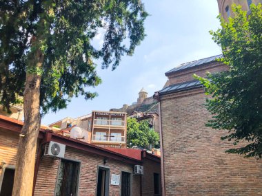 TBILISI, GEORGIA - 10 Temmuz 2018: Yazın eski Tiflis mimarisi, bahçesi, pencereleri, çiçekleri ve yeşil yaprakları.