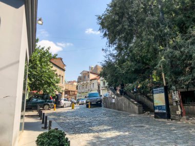 TBILISI, GEORGIA - 10 Temmuz 2018: Yazın eski Tiflis mimarisi, bahçesi, pencereleri, çiçekleri ve yeşil yaprakları.