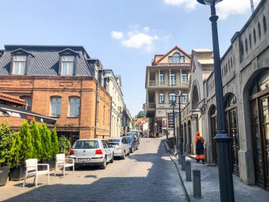 TBILISI, GEORGIA - 10 Temmuz 2018: Yazın eski Tiflis mimarisi, bahçesi, pencereleri, çiçekleri ve yeşil yaprakları.