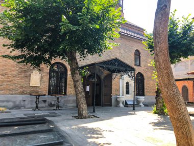 TBILISI, GEORGIA - 10 Temmuz 2018: Yazın eski Tiflis mimarisi, bahçesi, pencereleri, çiçekleri ve yeşil yaprakları.