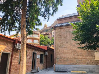 TBILISI, GEORGIA - 10 Temmuz 2018: Yazın eski Tiflis mimarisi, bahçesi, pencereleri, çiçekleri ve yeşil yaprakları.