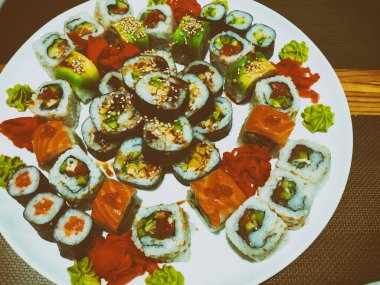 Beyaz bir tabakta farklı rulo çeşitleri. Geleneksel Japon Yemekleri.