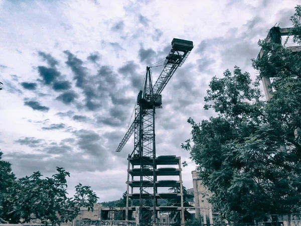 Construction of a high-rise building. Cranes construction hauling cargo. Blue sky.