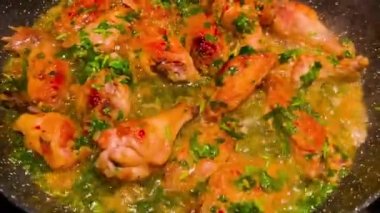 Lezzetli kavrulmuş tavuk kanatları ve üstünde de katlanmış otlar.