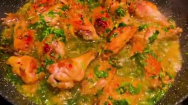 Lezzetli kavrulmuş tavuk kanatları ve üstünde de katlanmış otlar.