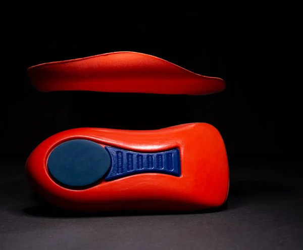 The orthopedic insole on a black background. Treatment and prevention of flat feet and foot diseases. High quality photo