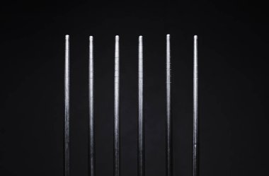 Siyah arka planda paslanmaz çelik çubuklar.