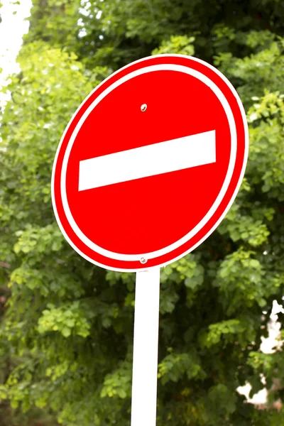 Un segnale rosso di stop con alberi sullo sfondo — Foto Stock