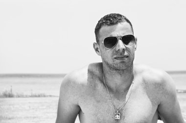 Çekici bir genç adam bir plajda portresi.