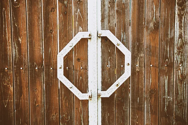 Старая коричневая деревянная дверь с металлическими ручками — стоковое фото