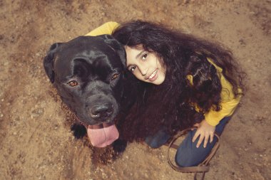 Küçük kız evde beslenen hayvan köpeğiyle oynuyor