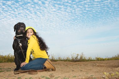 Küçük kız evde beslenen hayvan köpeğiyle oynuyor