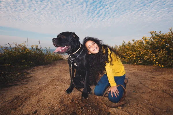 Küçük kız evde beslenen hayvan köpeğiyle oynuyor