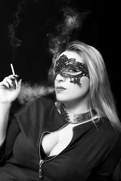 Hermosa joven fumando un cigarrillo sobre fondo negro — Foto de Stock