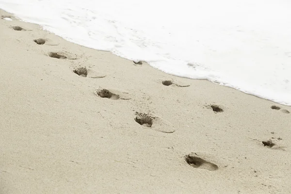 Voetafdrukken in het zandstrand — Stockfoto