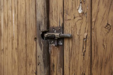 Kilitli eski kahverengi ahşap kapı, koruma detayları, antika ve terk edilmişlik.