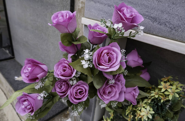 Detail of flowers on a grave, memory and sadness, death