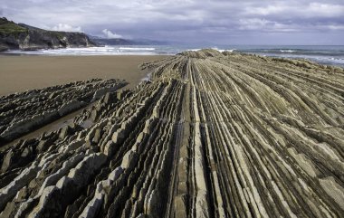 Sahildeki ünlü kaya oluşumunun detayları, erozyon ve doğa, turistik cazibe.