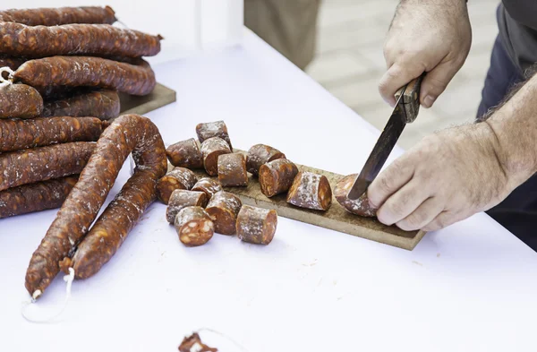 Розрізання ковбаси ножем — стокове фото