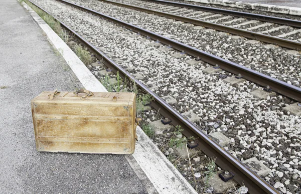 Old suitcase in a train station — Stock Photo, Image