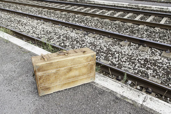 Old suitcase in a train station — Stock Photo, Image