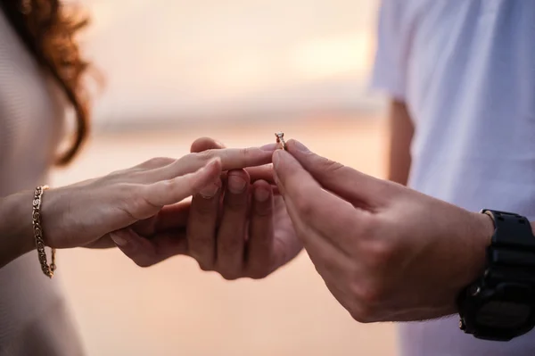 Noivo coloca o anel na mão da noiva — Fotografia de Stock