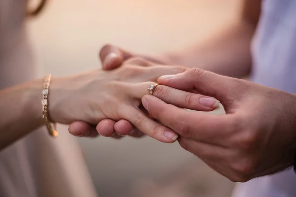 Brudgummen sätter ringen på brudens hand — Stockfoto