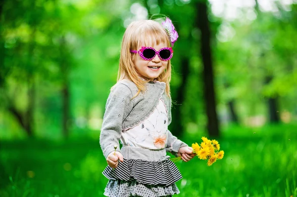 Ragazzina in occhiali da sole con fiori — Foto Stock